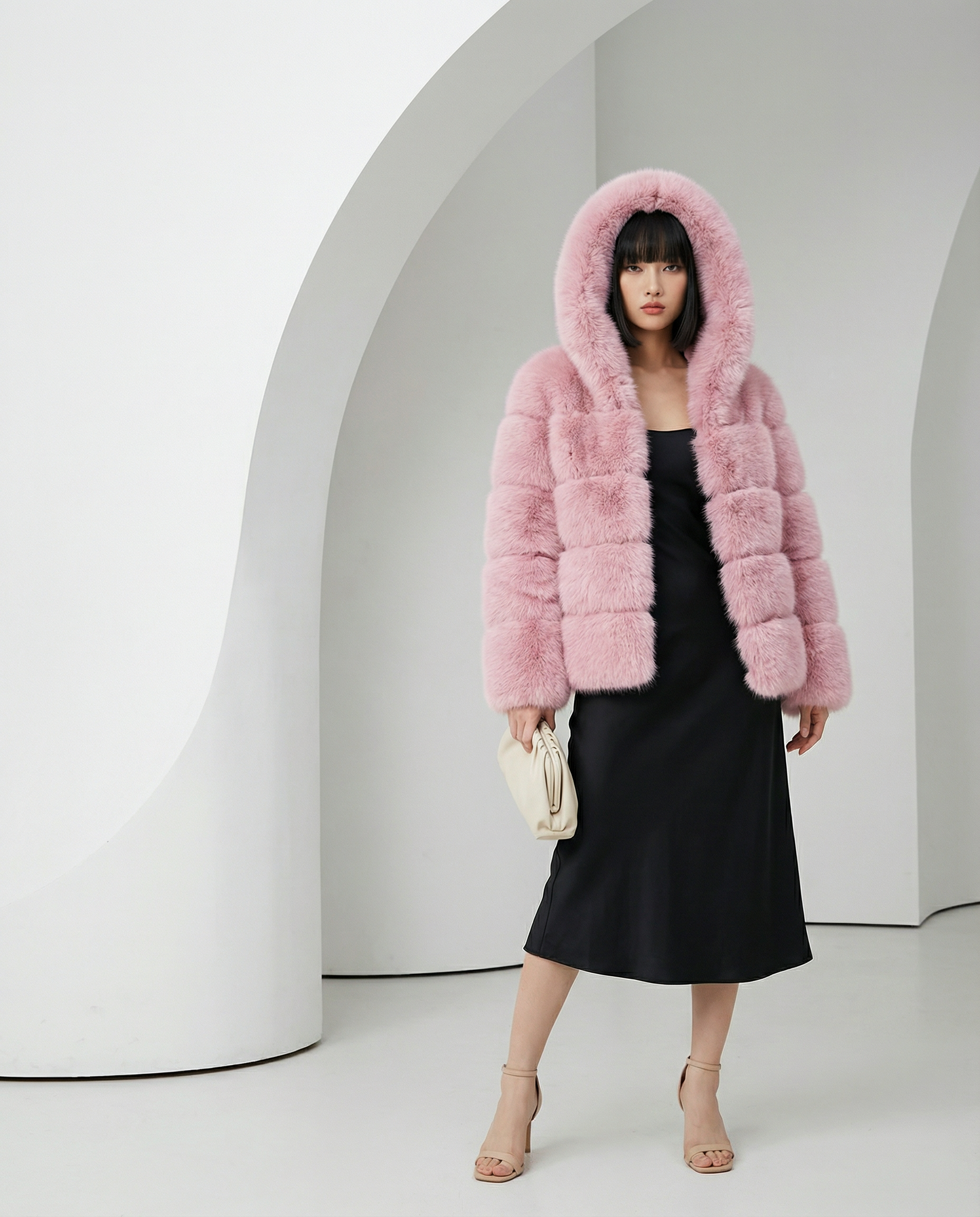 Nova faux-fur bubble jacket in rose pink with the hood up, worn over a black satin slip dress