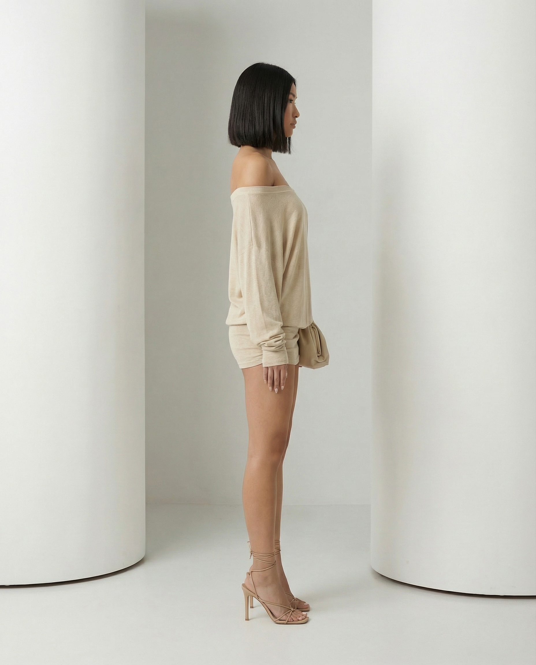 Side view of the beige Obsidian dress showing the draped bodice and short ruched skirt