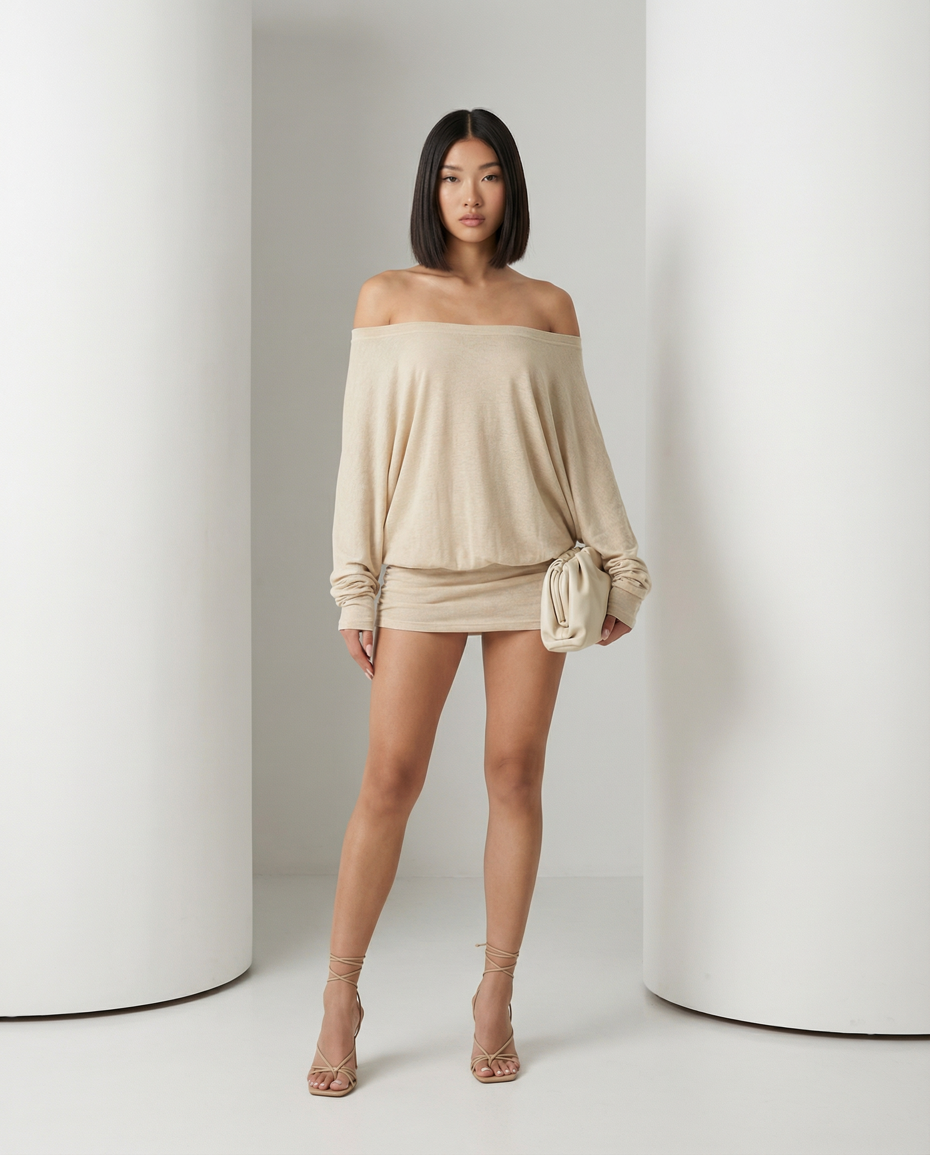 Off-shoulder beige mini dress with slouchy long sleeves and gathered skirt, standing front view