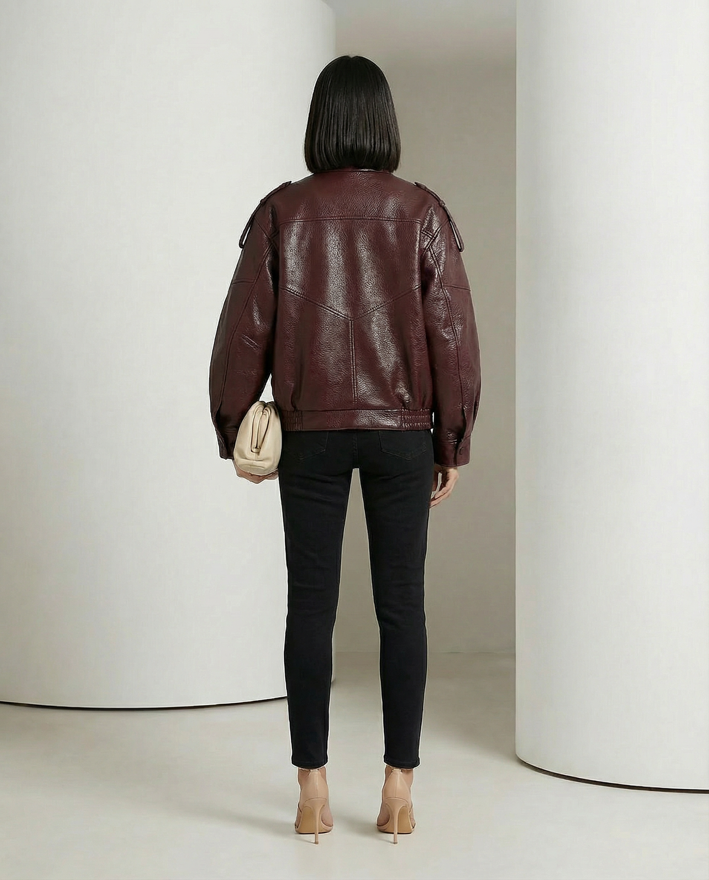 Burgundy leather-look bomber from behind, shoulder tabs and gathered hem, full length