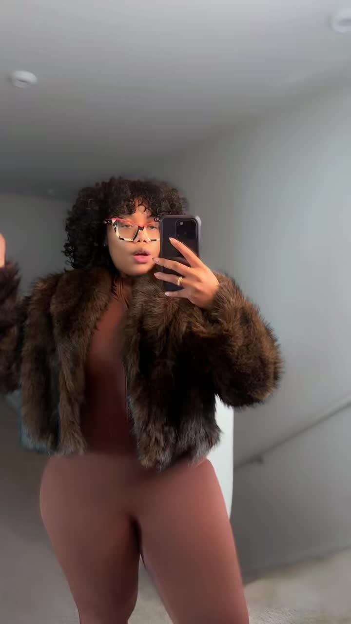 Mirror selfie in a cropped brown faux fur jacket over a matching brown bodysuit