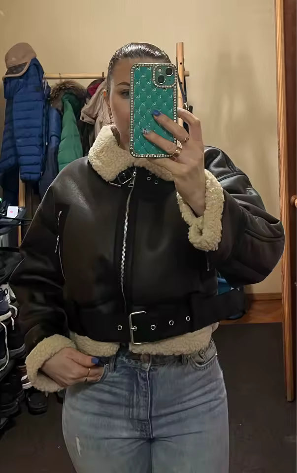 Belted aviator jacket with cream shearling trim over blue jeans, fitting-room mirror