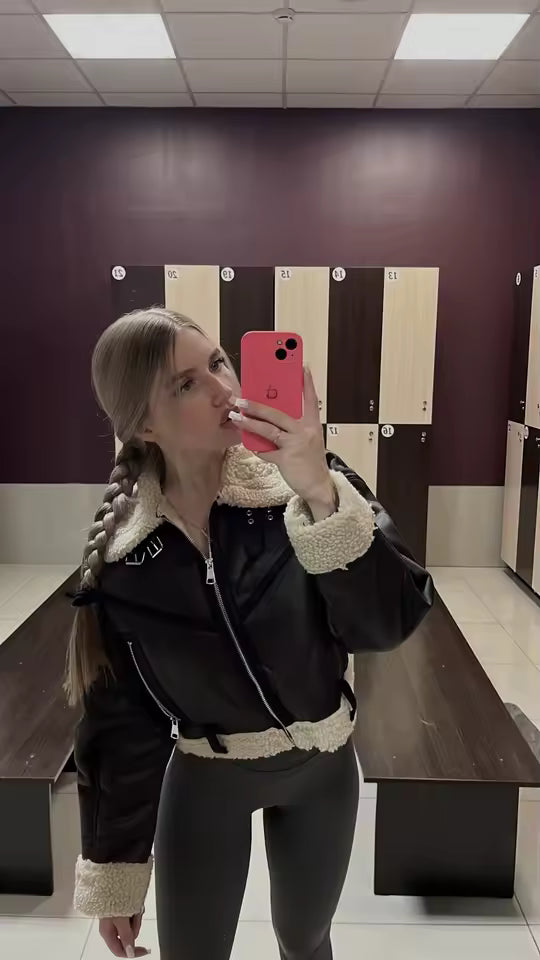 Black shearling-trim jacket with leggings, mirror selfie in a tiled locker room