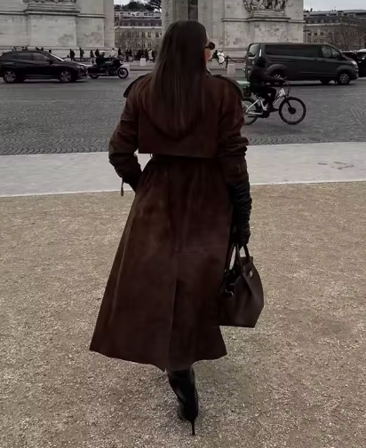 Long brown suede trench seen from behind with black gloves and heeled boots on a Paris street