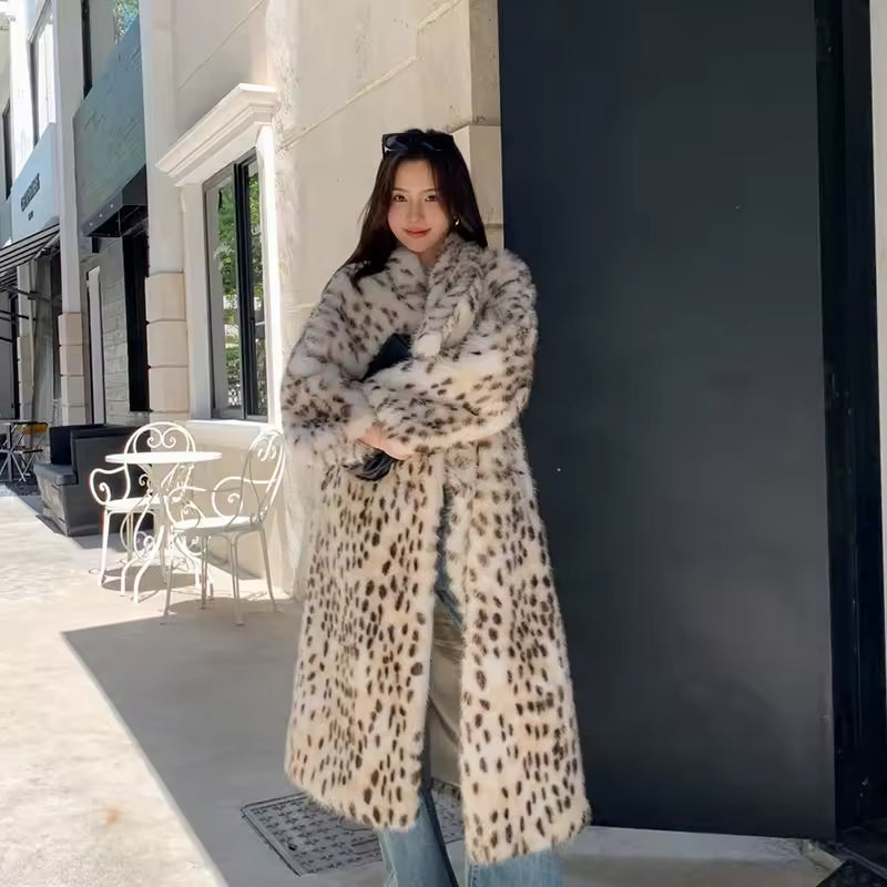 Long snow-leopard print faux fur coat worn over jeans on a sunlit city pavement