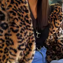 Leopard-print faux fur jacket worn open over a black top and blue jeans, cropped close