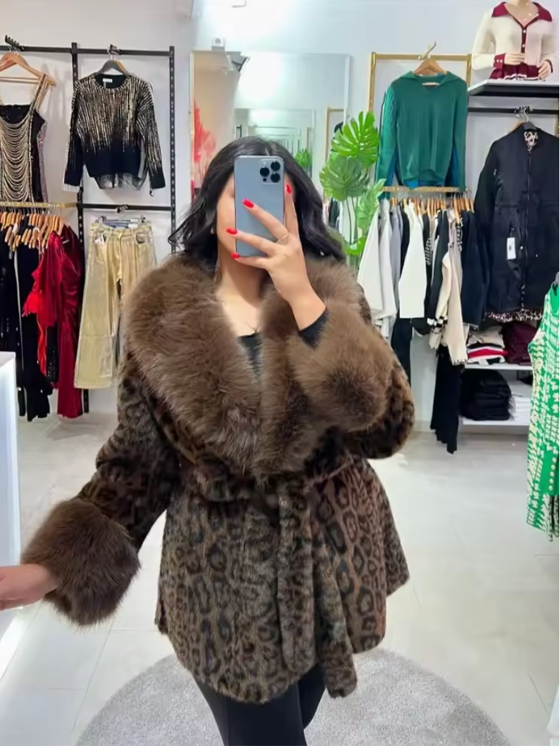 Mirror selfie in a belted leopard faux fur coat with brown fur collar and cuffs inside a shop