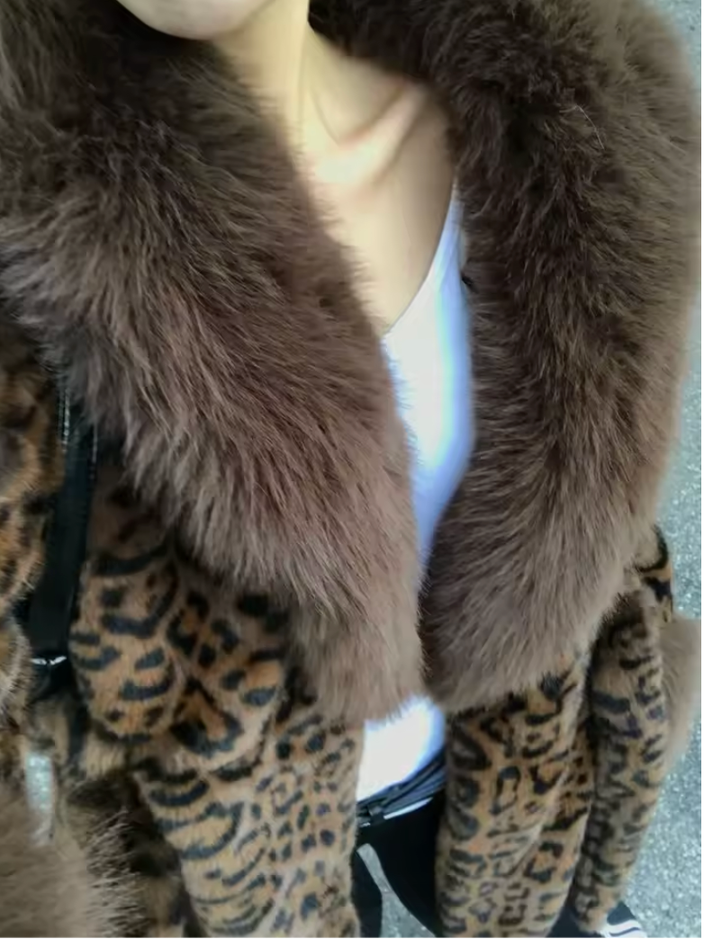 Close view of a brown fur shawl collar on a leopard coat worn over a white top