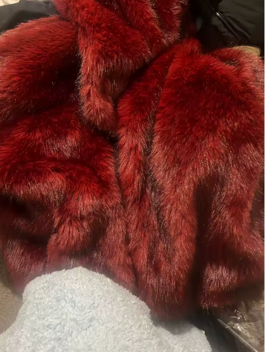 Close-up of dark red faux fur, showing the glossy two-tone pile and centre seam