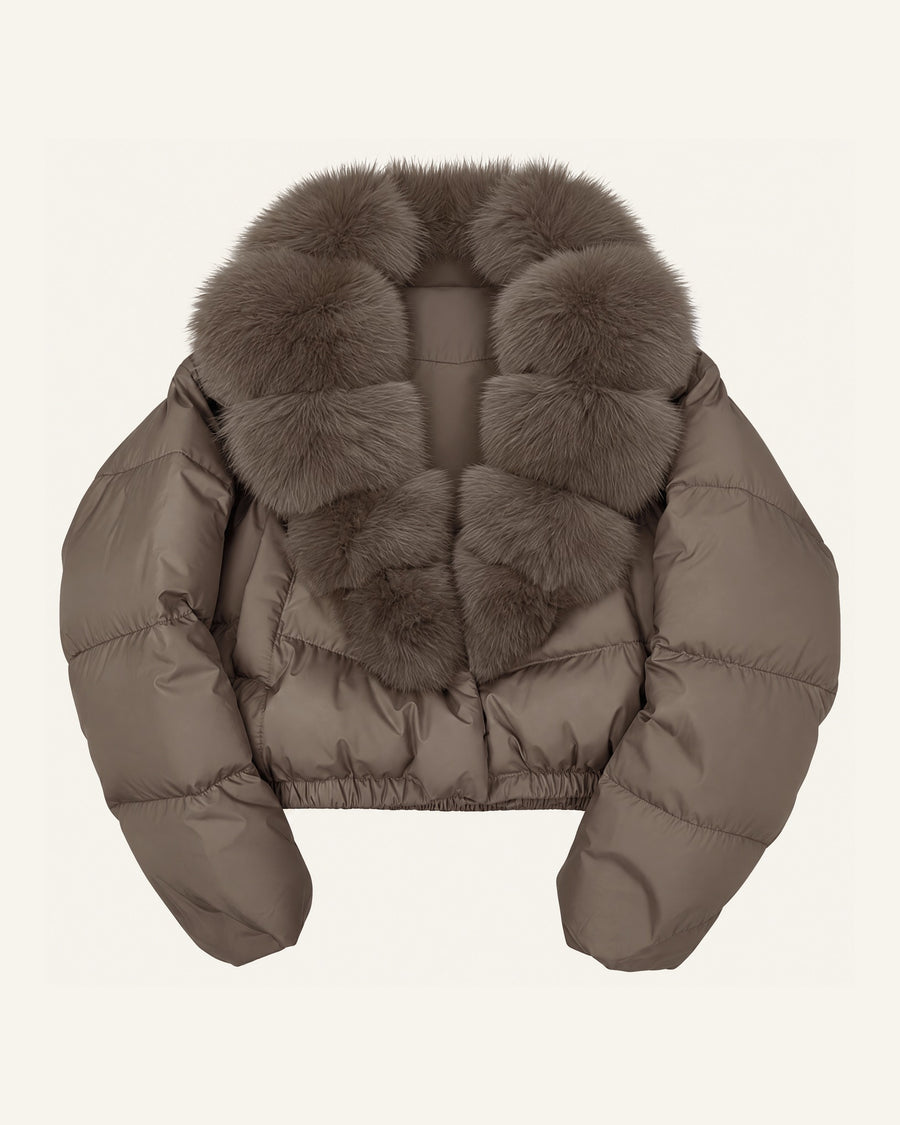 Model in the Saga cropped puffer in taupe, faux-fur shawl collar closed at the front, worn with black wide-leg trousers