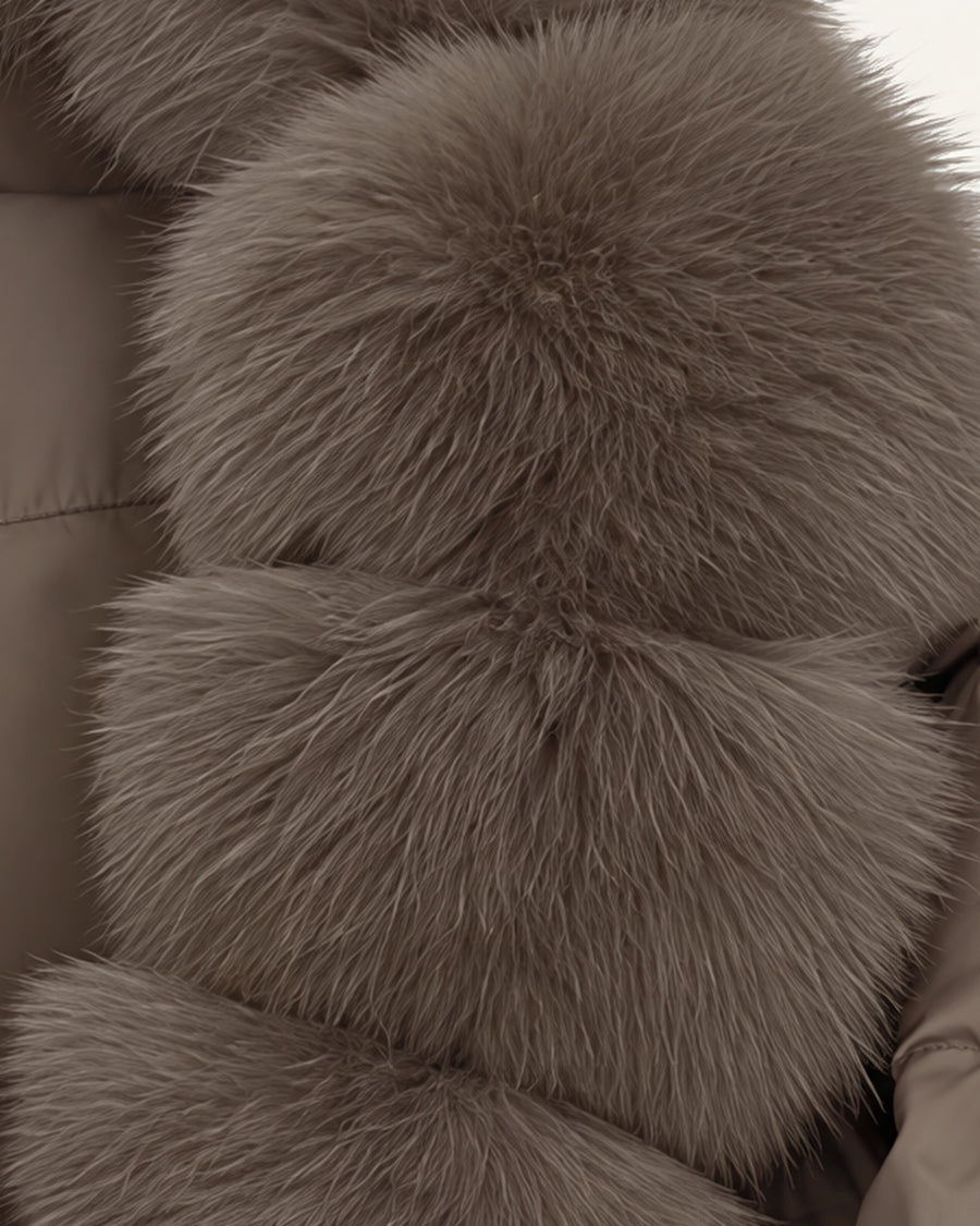 Model in the Saga cropped puffer in taupe, faux-fur shawl collar closed at the front, worn with black wide-leg trousers