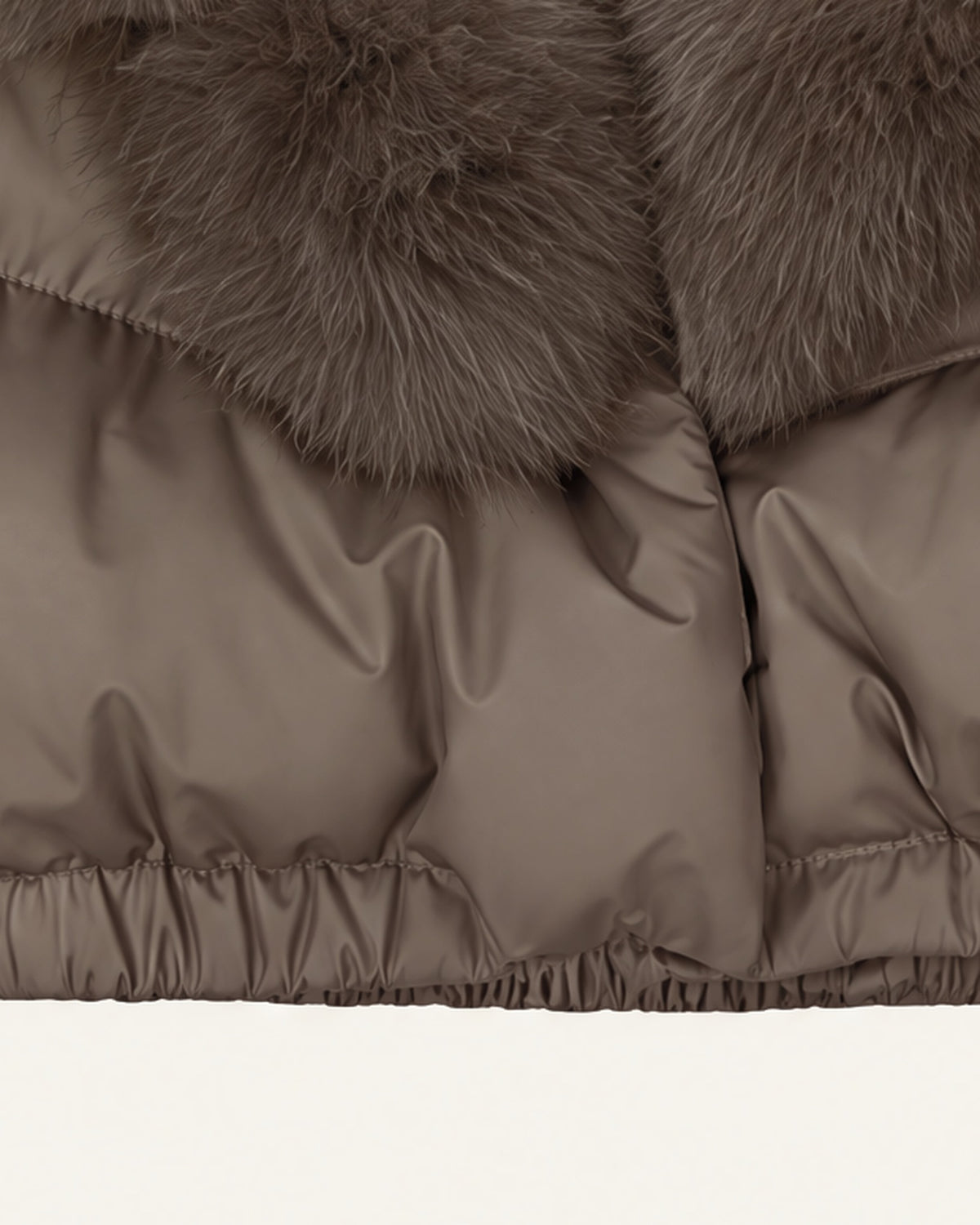 Close view of the Saga puffer hem, the gathered elastic waistband below wide horizontal quilted channels