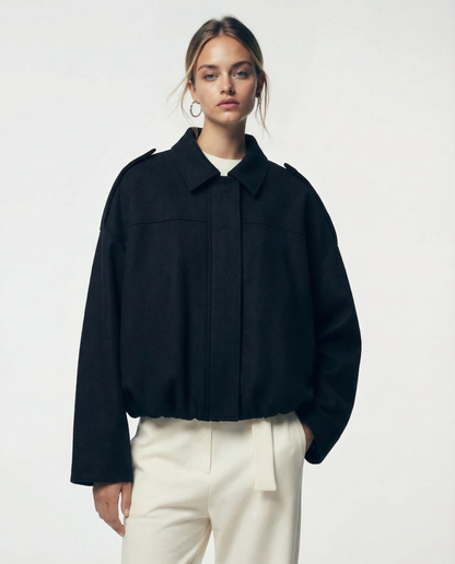 Black cropped bomber with a concealed placket front and shoulder tabs, straight-on view from the hip up