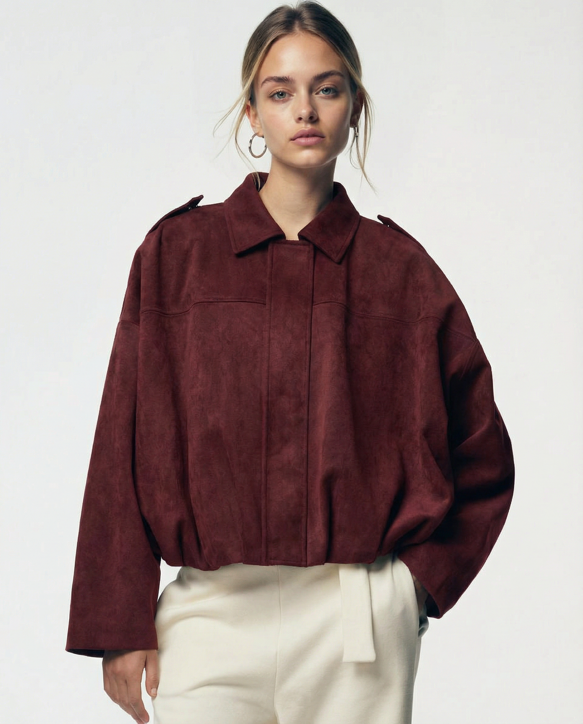Burgundy suede Selena Jacket fastened closed over cream trousers, close front view from the hip up