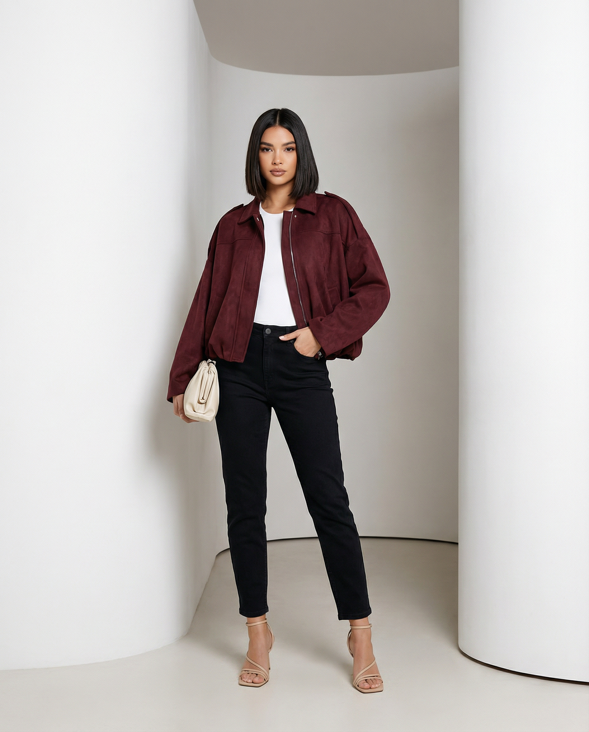 Burgundy suede jacket worn open with one hand in a jean pocket, relaxed standing pose, full length