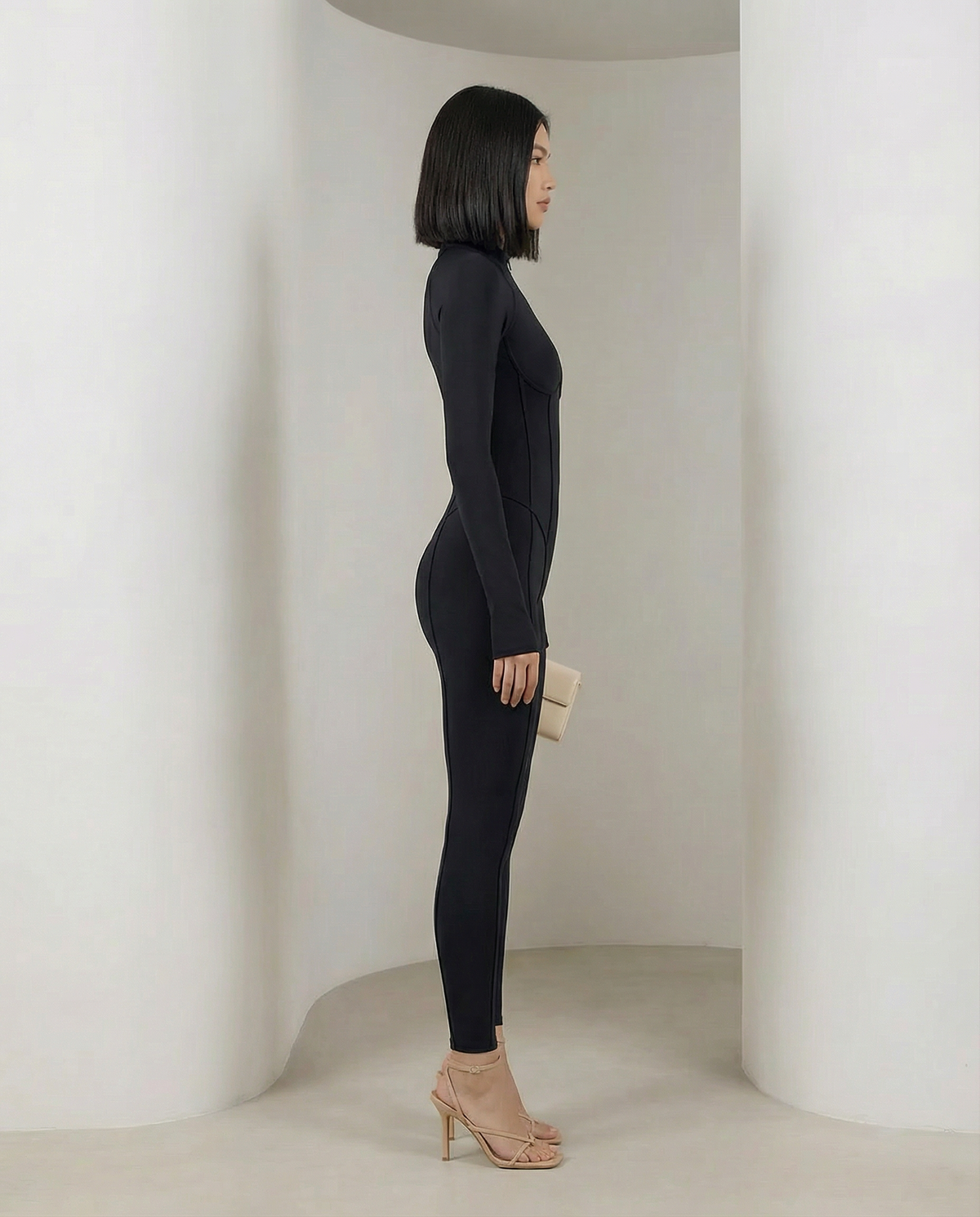 Black Selene Sculpt Jumpsuit in strict side profile showing the smooth ankle-length leg line