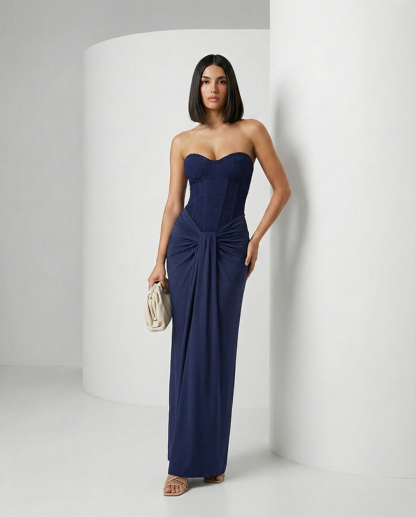 Navy strapless corset maxi dress with a draped hip knot, standing full length front view