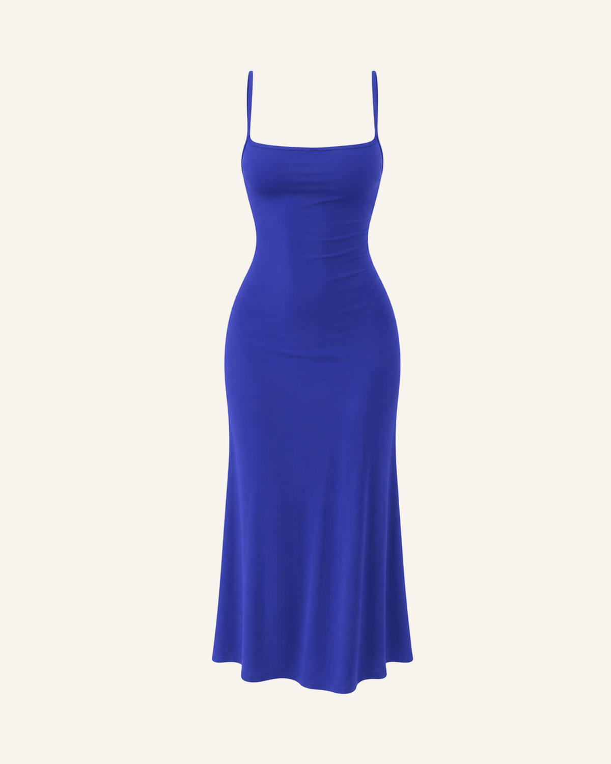 The Siv midi slip dress in cobalt blue, narrow straps, straight neckline and a fluted hem, alone on a bone background