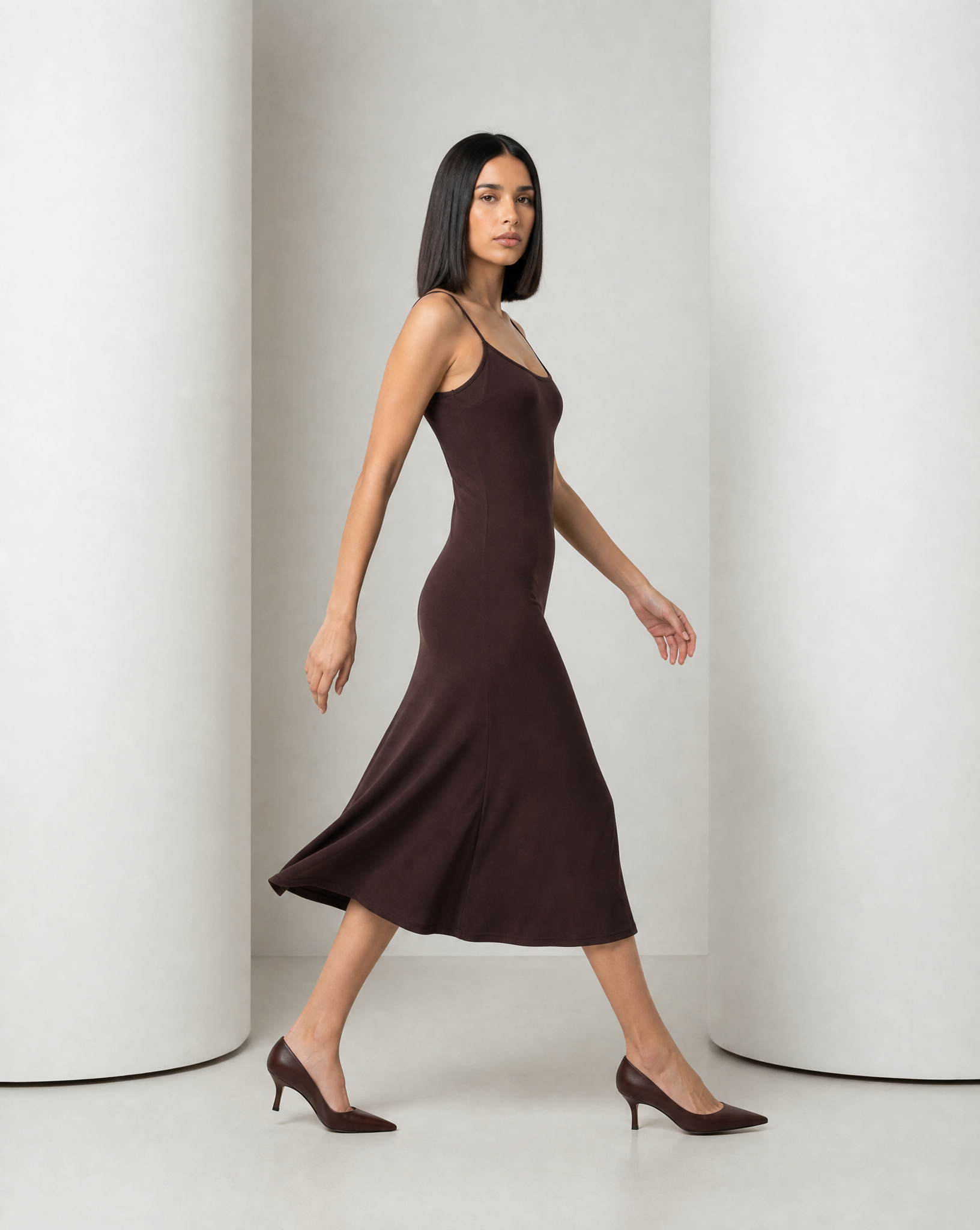 Side view of the Siv espresso slip dress in movement, the skirt swinging away from the hip