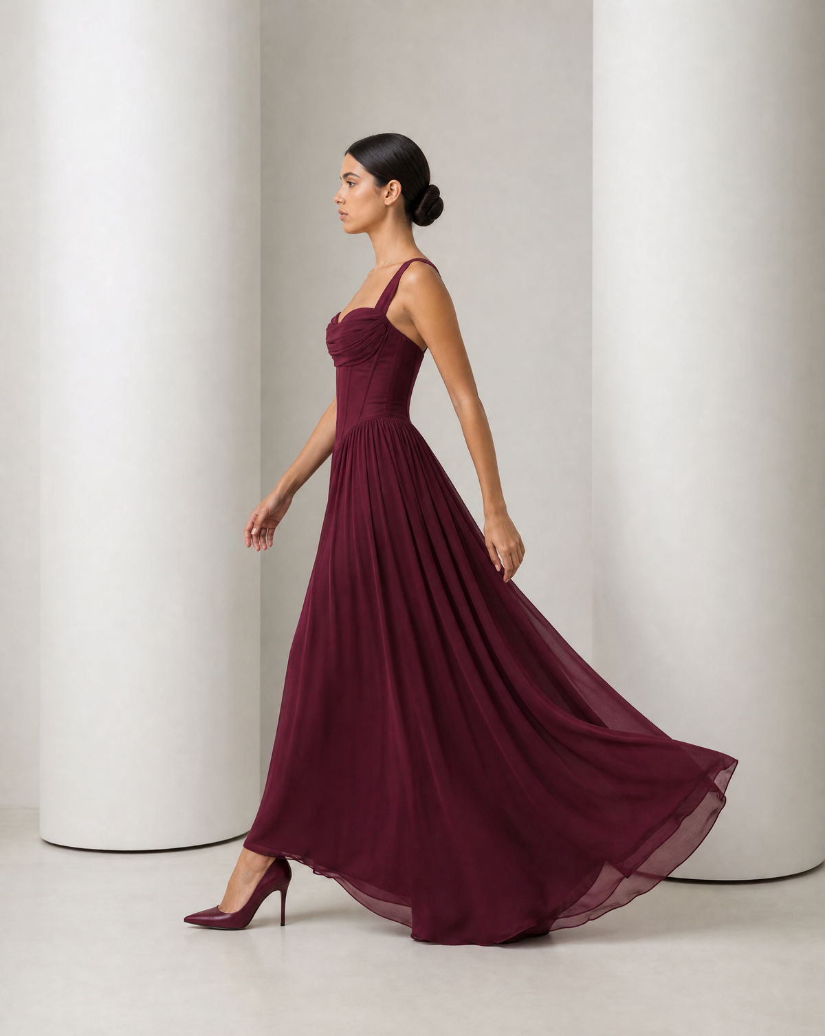 Side view of the Solveig burgundy gown in movement, skirt sweeping to the floor