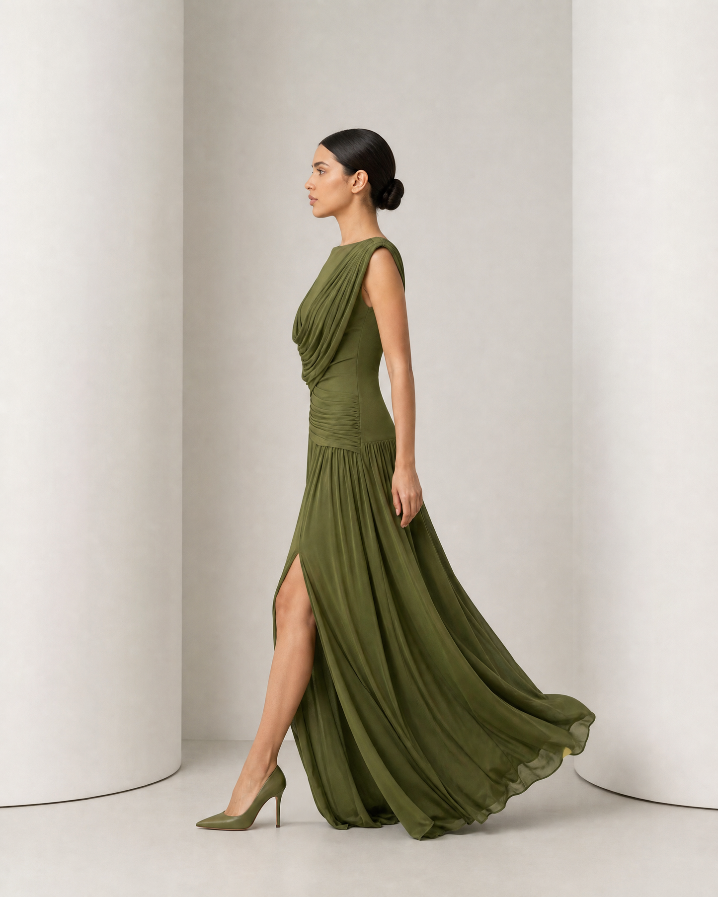Side view of the olive Thora gown in movement, gathered skirt swinging and the hem trailing