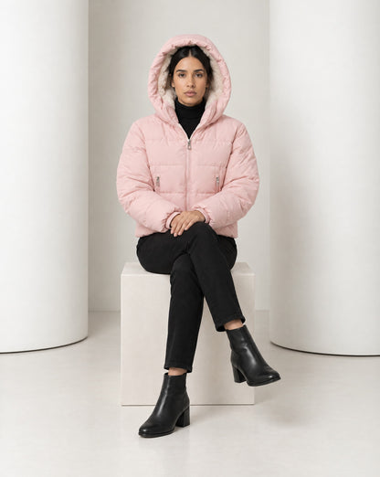 Tove puffer in pink worn seated with the teddy-lined hood pulled up over the head