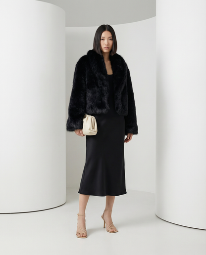 Black Vera faux-fur jacket worn open over a black slip midi skirt, full length front view