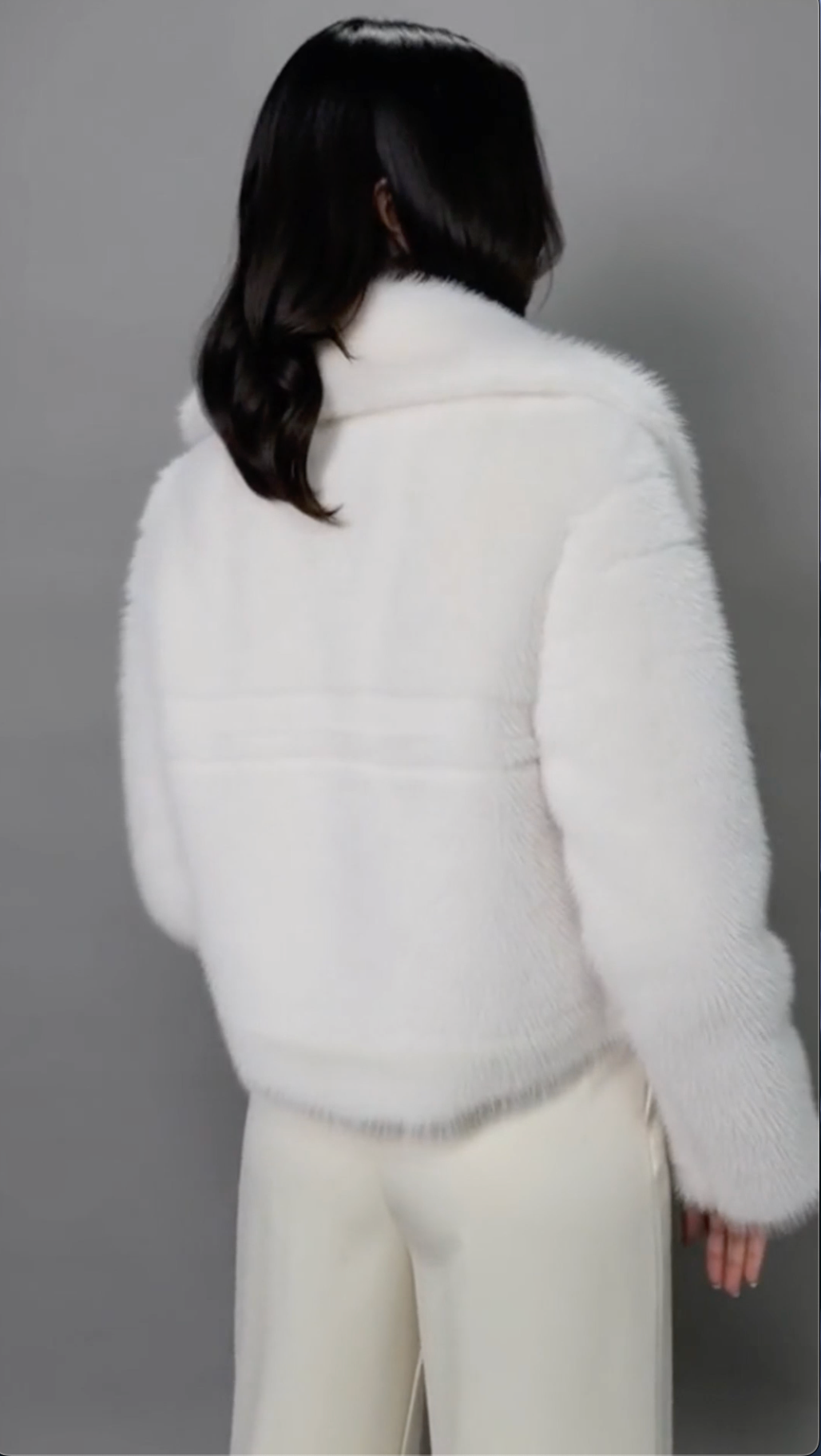 Back view of the ivory cropped faux-fur jacket showing the collar and centre back seam