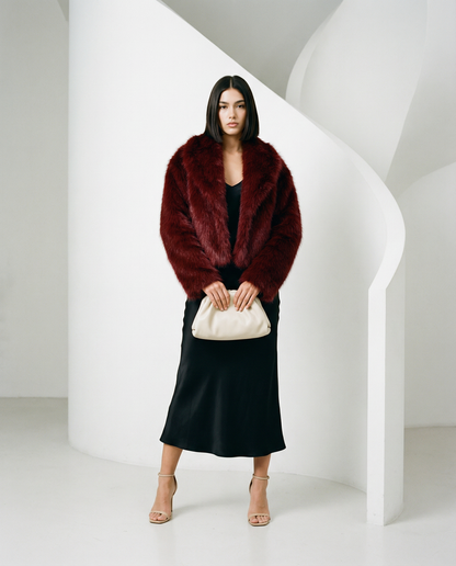 Burgundy Vera faux-fur jacket worn open over a black slip midi dress, full length front view