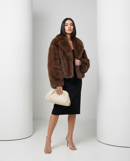 Cropped cocoa brown faux-fur jacket worn open, three-quarter stance with a cream leather pouch clutch