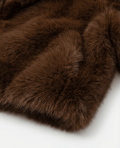 Close detail of the dense cocoa brown faux fur, showing pile texture and the swept sleeve seam