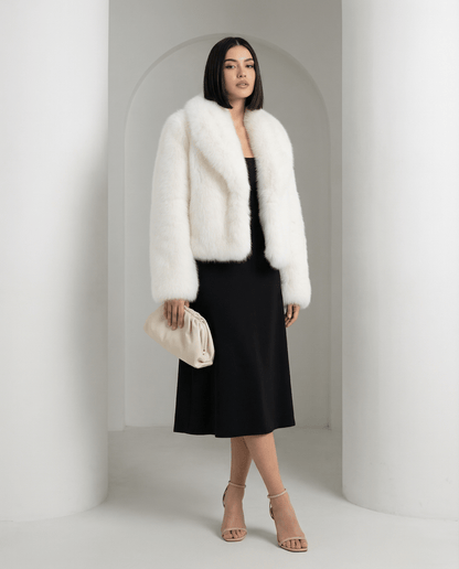 Vera faux-fur jacket in ivory white, shawl collar turned back, standing in an arched alcove