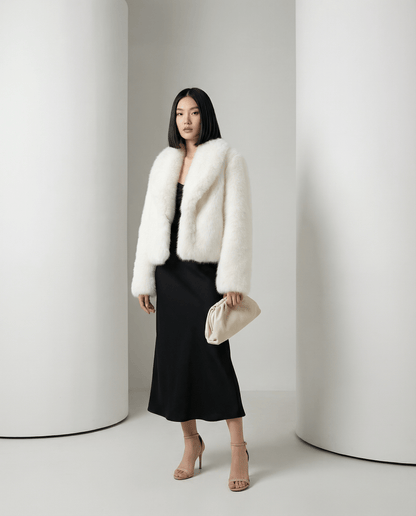 Cropped ivory faux-fur jacket with long full sleeves, three-quarter view with a cream pouch bag