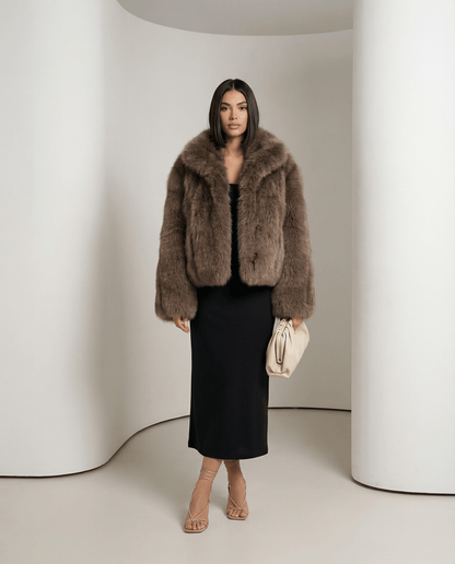 Vesper faux-fur jacket in warm taupe worn open over a black column dress, full-length front view