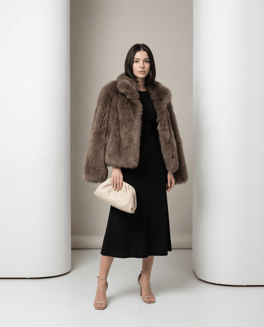 Taupe Vesper faux-fur jacket, cropped with a shawl collar, worn over a black midi skirt